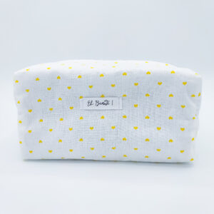 trousse blanche sur fond blanc avec des motifs de coeurs jaunes