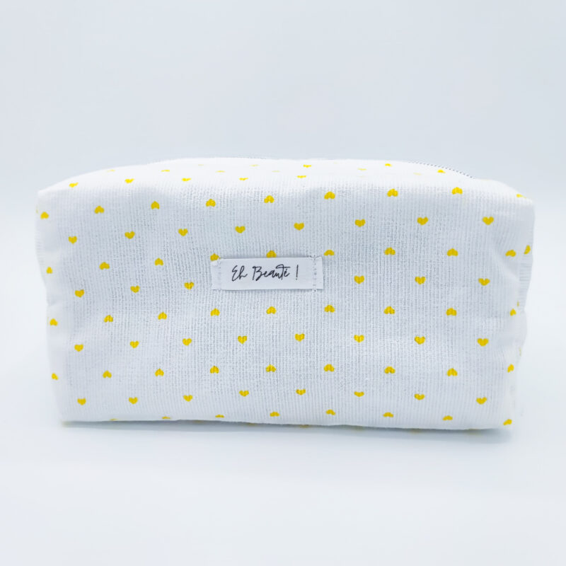 trousse blanche sur fond blanc avec des motifs de coeurs jaunes