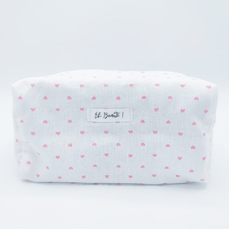 trousse blanche sur fond blanc avec des motifs de coeurs roses