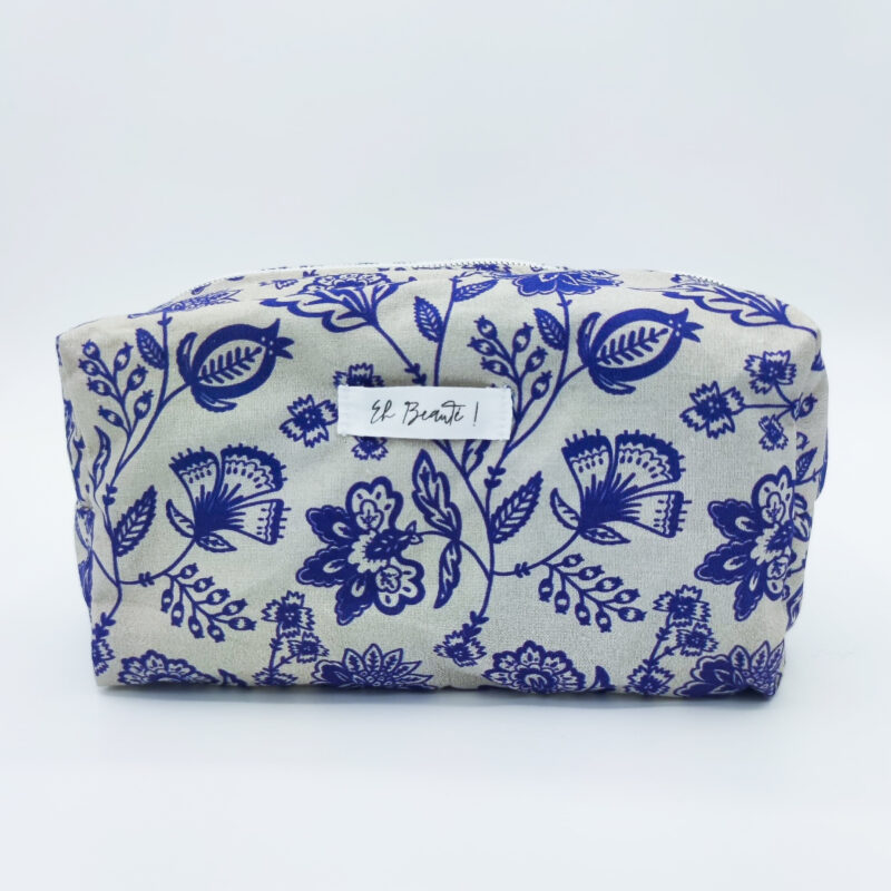 trousse blanche sur fond blanc avec des motifs de fleurs bleus